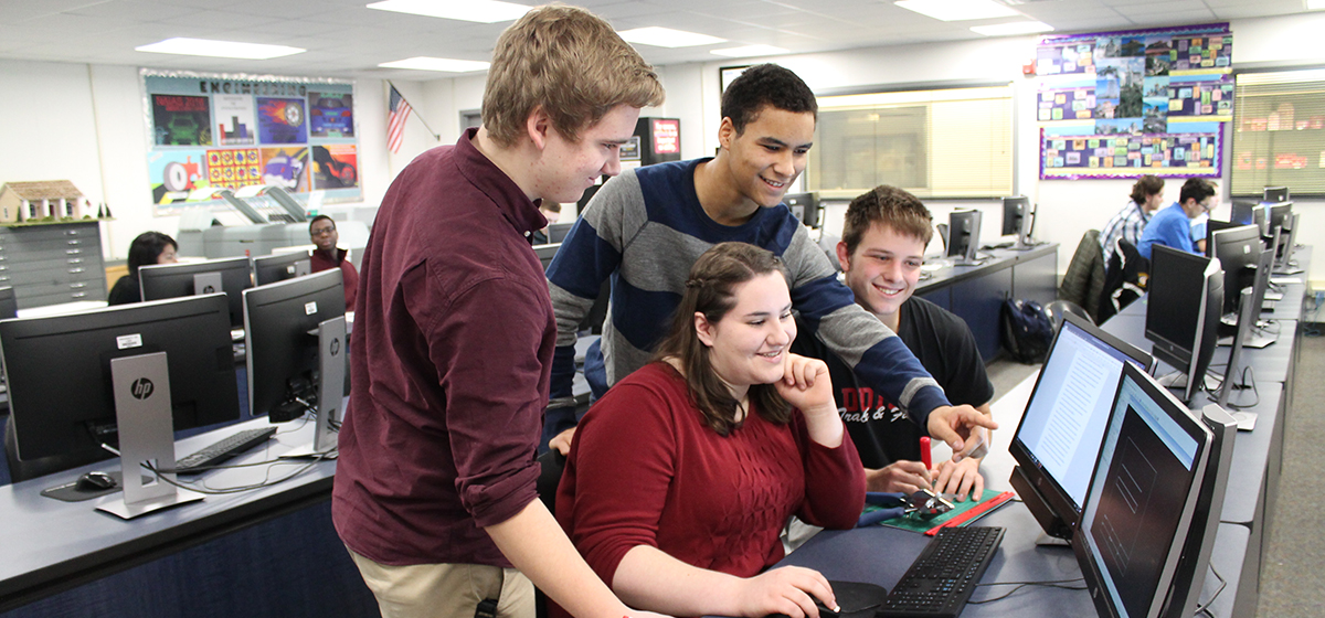 Four engineering students looking at classroom computer