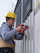 Student drilling home siding